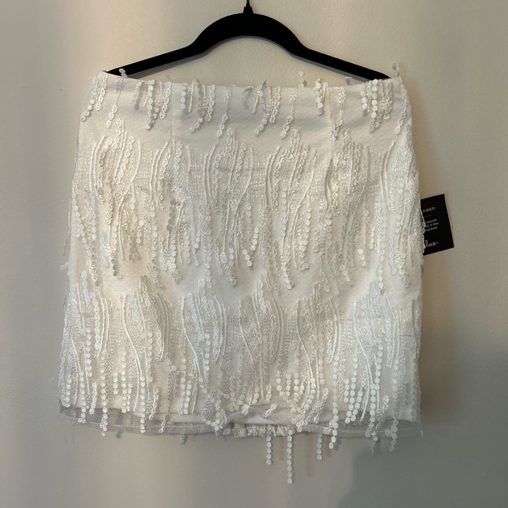 A white skirt with dangling glitter strings. Brand new